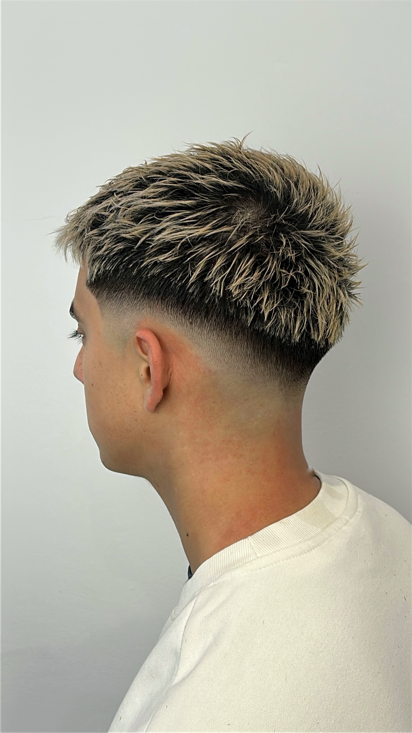 Blonder strukturierter Herrenhaarschnitt mit sauberem Fade